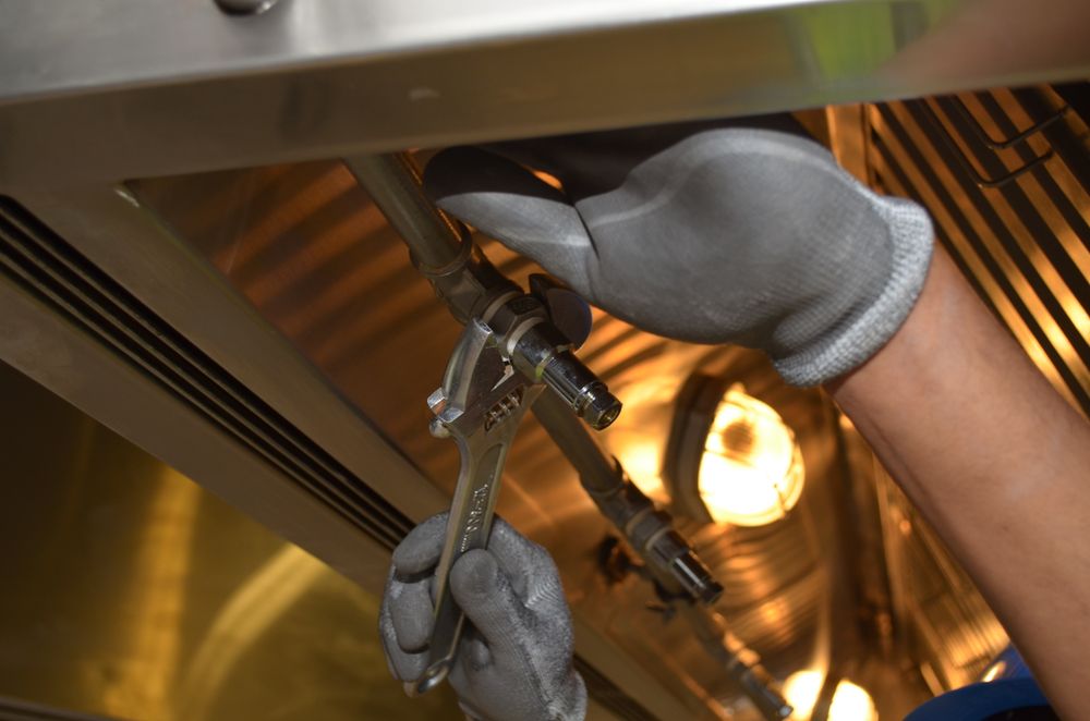 Commercial kitchen plumbing service on a stainless steel prep line in Sacramento