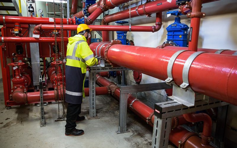 Engineer inspecting commercial pipework for cross-connections in Sacramento