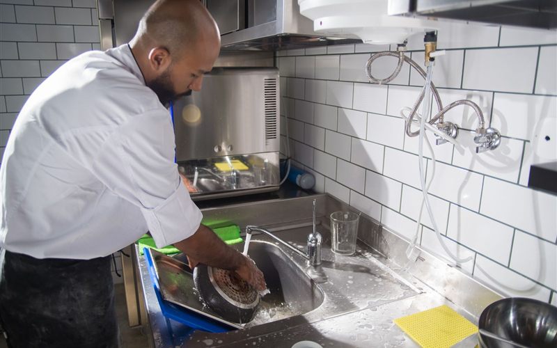 Commercial dishwashing station plumbing in a Sacramento restaurant kitchen