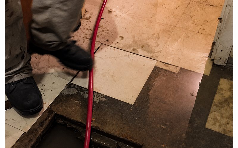 Grease trap cleaned through a floor cleanout with a jetter hose in a Sacramento commercial kitchen