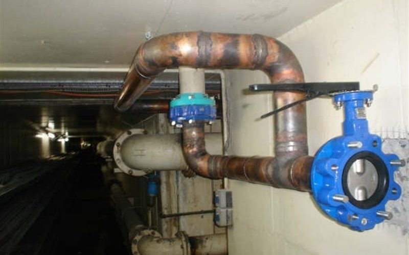 Copper hot-water distribution piping and butterfly valve in a Sacramento mechanical room