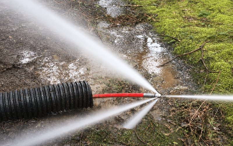 Hydro jetting nozzle clearing a commercial drain line at high pressure in Sacramento