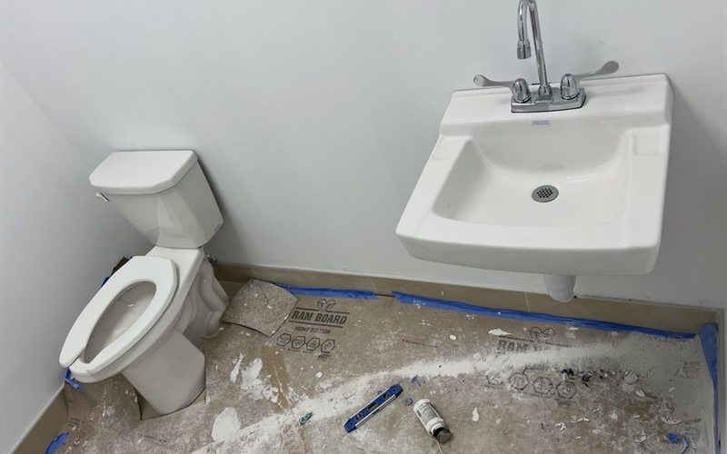 Newly installed commercial toilet and wall-hung lavatory in a Sacramento restroom fit-out
