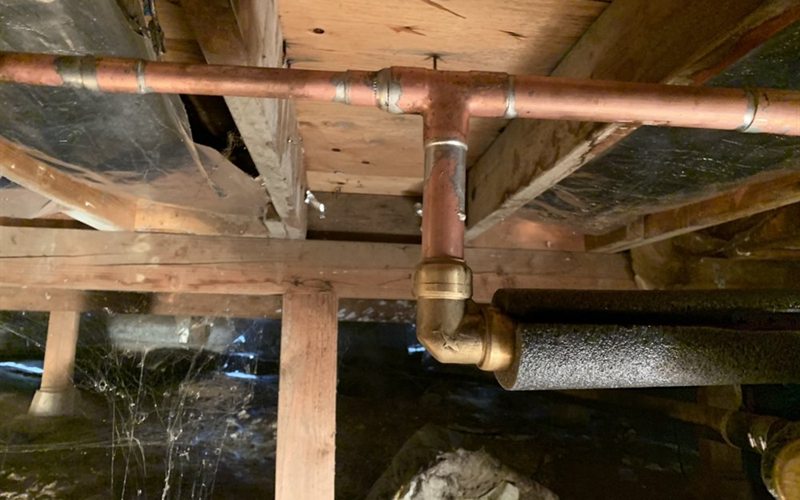 Copper hot-water line and brass fitting repaired under a Sacramento commercial building