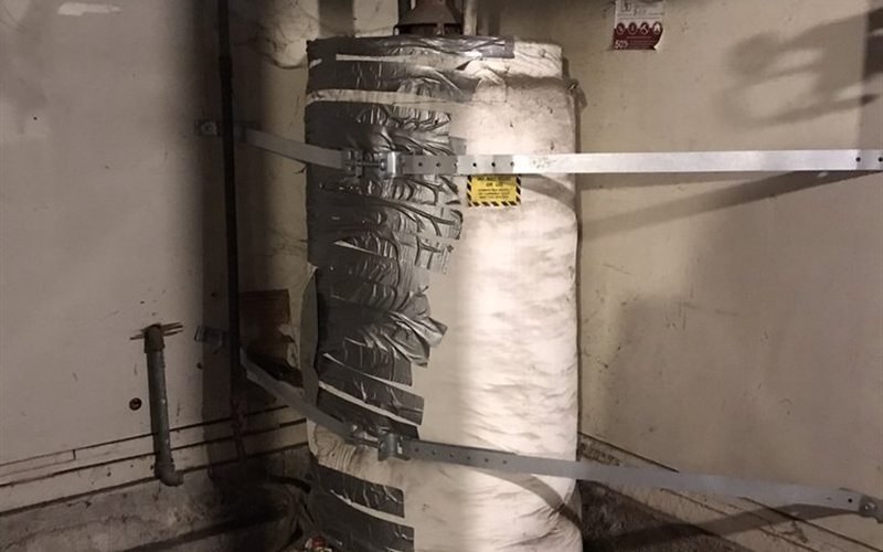 Commercial water heater with insulation jacket and seismic strapping in a Sacramento building